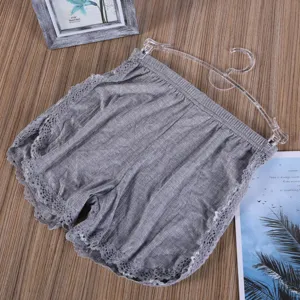 Dettaglio ravvicinato di pantaloncini casual da donna grigi con delicato bordo in pizzo.