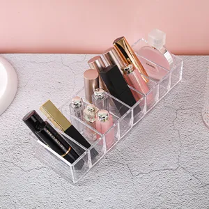 Transparante acryl bureau organizer met meerdere vakken voor lippenstift en kabels.