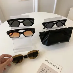 Set di occhiali da sole eleganti con espositori trasparenti e custodia in pelle nera.