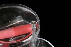 Close-up detail of transparent rotating storage box, clear acrylic material, screw hinge.
