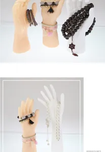 Detail view of mannequin hands displaying various beaded bracelets and jewelry pieces clearly.
