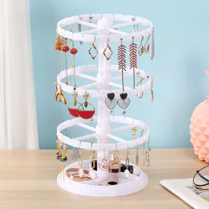 White multi-tier rotating jewelry organizer stand for earrings and bracelets display.