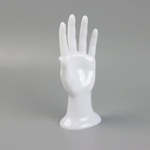 White glossy mannequin hand jewelry display stand for showcasing rings bracelets and gloves.
