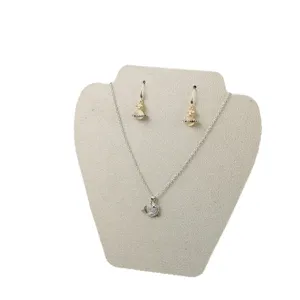 Elegant silver tone necklace and Saturn drop earrings jewelry set displayed on a stand.