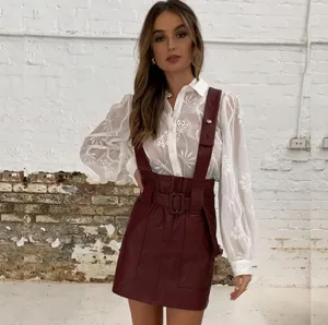 Elegant women's embroidered puff sleeve long sleeve blouse matched with chic faux leather skirt.