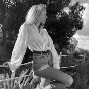Detailed view of women's long sleeve embroidered puff sleeve blouse in outdoor setting.