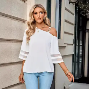Détail du chemisier blanc décontracté asymétrique pour femme avec manches en tulle et boucle métal.
