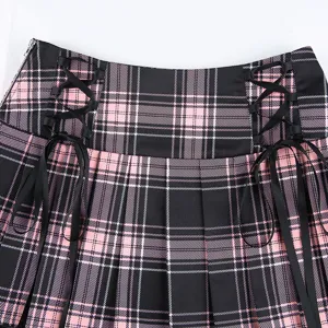Close-up detail of black and pink plaid pleated mini skirt featuring side ribbon lace-up design.