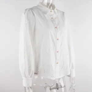 Detail view of white long sleeve blouse with delicate eyelet embroidery and bubble sleeves.