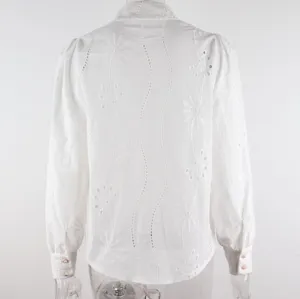Detailed view of the white long sleeve blouse showcasing intricate eyelet embroidery and sleeve details.