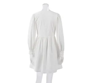 Detail view of white long sleeve dress back, bubble sleeve design, elegant fabric texture.
