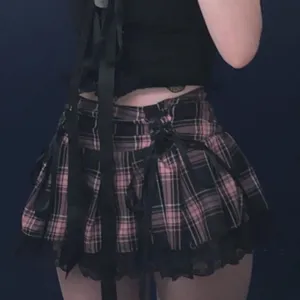 Pink and black plaid pleated miniskirt with cross ribbon straps and cute black lace trim.