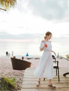 Detailed view of the white off-shoulder bohemian beach dress, featuring delicate lace embroidery.