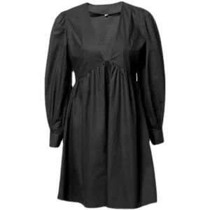 Close-up details of the black long-sleeve dress with deep V-neck and chic puff sleeves.