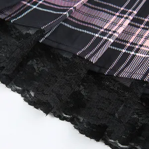 Plaid pleated skirt detail featuring black pink blue pattern and layered black lace trim close-up