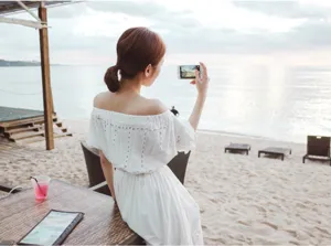 White bohemian off-shoulder beach dress detail view, showing delicate eyelet embroidery.