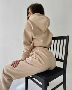 Women casual tracksuit detail view featuring long sleeve hoodie and matching sweatpants in beige.