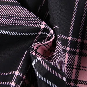 Close-up van de zwart-roze ruitstof met weergave van textuur en patroondetails van de rok.
