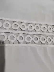 Détail cardigan cache-maillot de plage en dentelle blanche, élégant maillot soleil été.