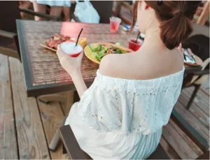 Detail view of a white off-the-shoulder bohemian dress, perfect for seaside beach vacation.