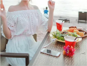 White off-shoulder bohemian dress, elegant lace cutout design for summer beach vacation.
