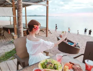 Beach resort scene detail showing the back view of the white off-shoulder bohemian dress.