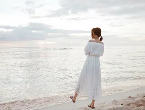 Details of the white bohemian beach long dress, off-shoulder style for seaside summer vacation.