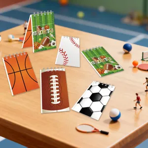 Gedetailleerde opname van mini spiraalnotitieboekjes met diverse sportmotieven op tafel.