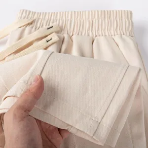 Close-up detail of men's casual cotton trousers showing fabric texture and waistband.
