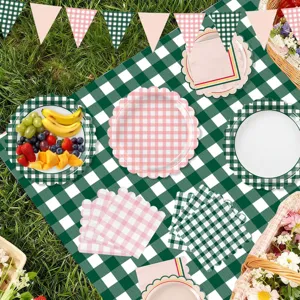 Picnic party decoration set with green checkered tablecloth, floral paper plates, and bunting.