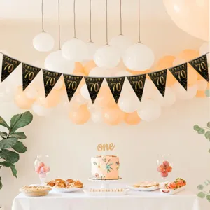 Black and gold 70th birthday banner hanging scene detail, elegant party decoration setup backdrop.