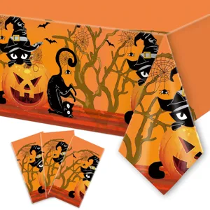 Halloween tablecloth detail showing cute black cat and pumpkin pattern design for party.