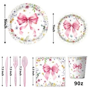 Ensemble de vaisselle de fête floral avec nœud rose assiettes tasses serviettes et couverts.