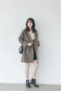 Detail view of the stylish plaid wool coat featuring fine texture and elegant design.