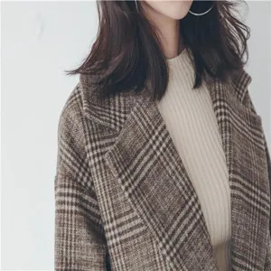 Close-up detail of stylish women plaid wool blend coat with classic collar and soft texture.