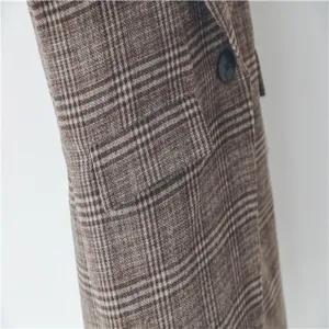 Plaid wool coat pocket and button detail close up view, warm winter outerwear close-up