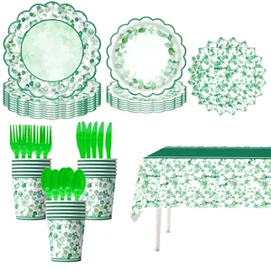 Vista dettagliata delle forniture per feste eucalipto con piatti, tazze e posate botaniche.