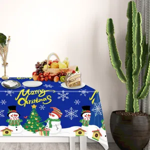 Christmas tablecloth detail showing festive snowman pattern and blue holiday party decoration setup.