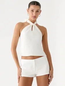 Detailed view of white satin halter neck top with tie back, elegant sleeveless design for women.