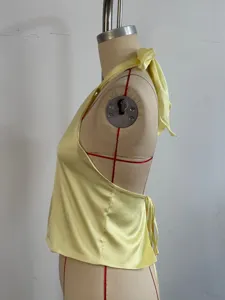 Yellow satin halter top for women, sexy backless tie-up design, smooth summer apparel detail.