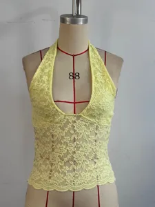 Vue détaillée du débardeur halter en dentelle jaune, motif floral et bas festonné.