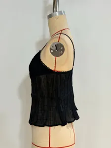 Vista de cerca del top plisado negro con delicado ribete de encaje y diseño sin mangas.