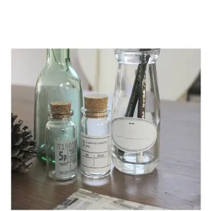 Clear glass bottles with corks and vintage style labels, ideal for DIY crafts, home decor.