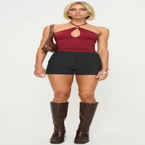 Women's summer solid color sleeveless halter crop top with black shorts and brown boots.