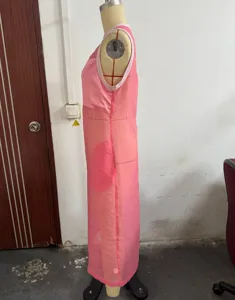 Vestido largo rosa sin mangas vista lateral, detalle de tela ligera semitransparente.