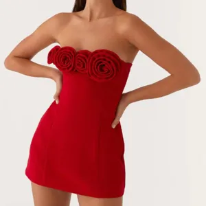 Red strapless mini dress featuring gorgeous 3D fabric roses on the bust. Chic detail view.