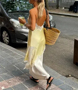 Yellow satin slip dress street style detail, featuring delicate white lace trim and layer.