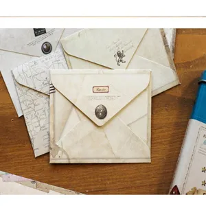 Dettaglio ravvicinato di piccole buste creative in stile vintage con stampe postali.
