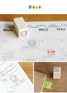 Detailed view of cute wooden cat stamps in use on calendar grid, high quality stationery.