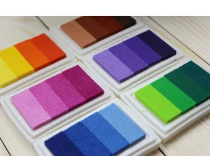 Detailed close-up of colorful gradient stamp pads arranged neatly on wooden background.